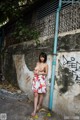 A woman standing in front of a wall with graffiti on it.